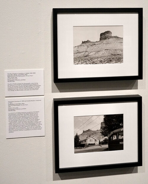 Two framed photographs hang on the wall of a gallery each depicting the same landscape in different ways.