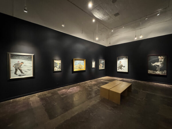 Figurative paintings hang in a black-walled gallery.