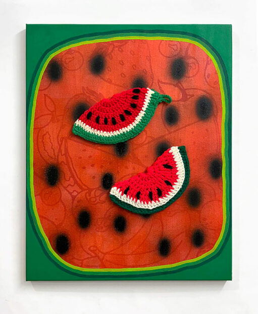 A green painting with a red center and two crocheted watermelon potholders attached to the surface.