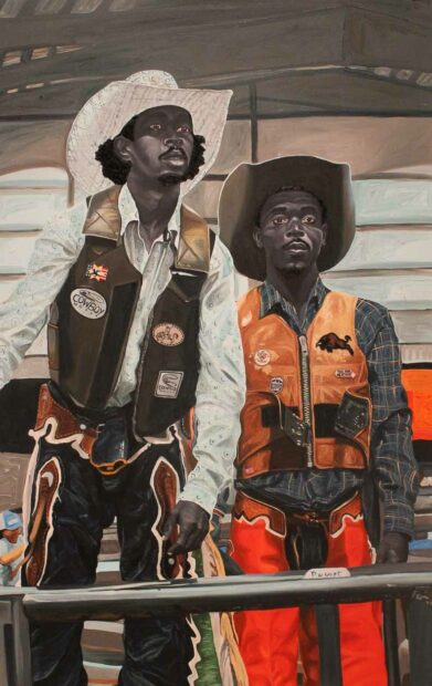 Two Black cowboys stand side by side.