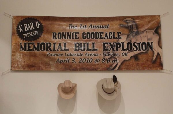 A large poster hangs on the wall with two cowboy hats.