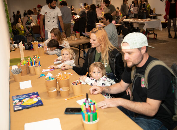 A photograph of families participating in art activities at an event.