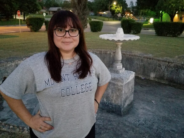 A photograph of Mary Cantú wearing a Mount Holyoke College shirt. 