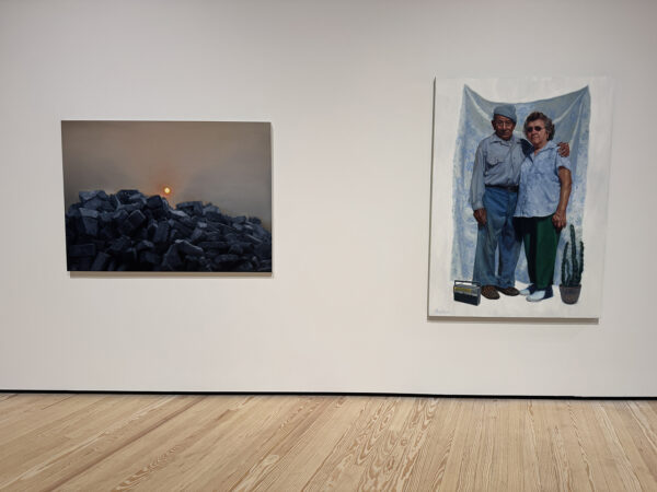 An installation image of a landscape and portait painting by Vincent Valdez.