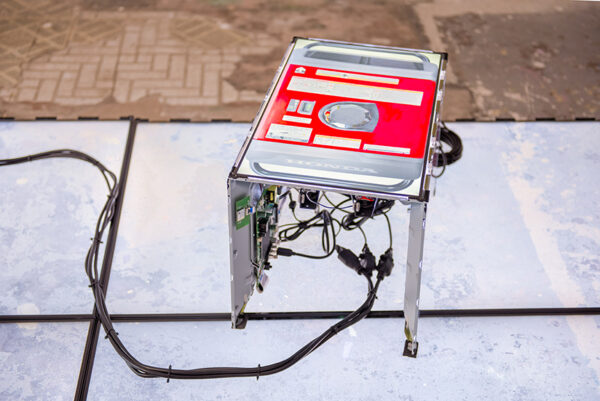 A sculpture, made of conjoined flat screen video screens sit atop a pedestal of four large flat screen TVs in a gallery.