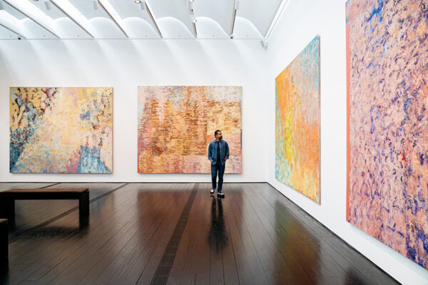 A museum houses several large canvases in multiple rooms.
