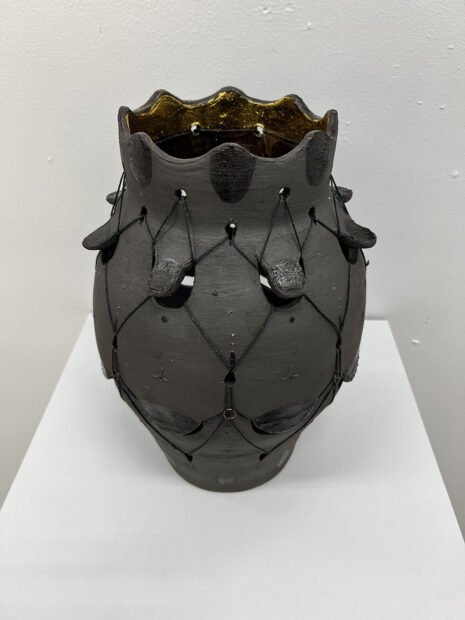 A photograph of a black ceramic vase by Makenzie Bierma.