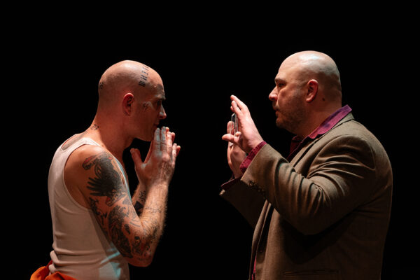 A photograph of two actors confronting each other as part of the play "Rift or White Lies."