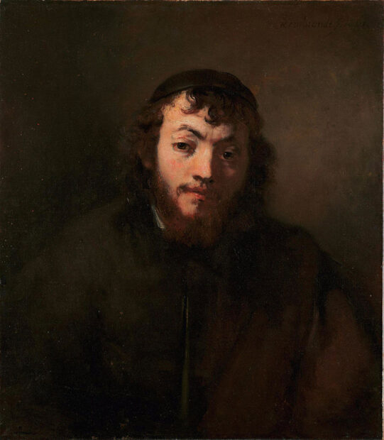 A portrait of a young man in a dark shirt.
