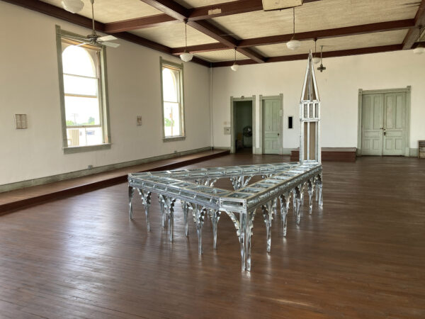 Inside the top floor of building, a section of a steeple is constructed out of steel studs