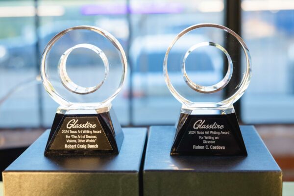 Two small-scale trophies, made of glass and shaped like car tires, sit atop boxes.