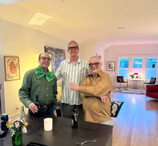 A photograph of Steve Press and Robert Wray stand with artist Ibsen Espada.