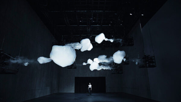 A photograph of a person walking through an immersive space.